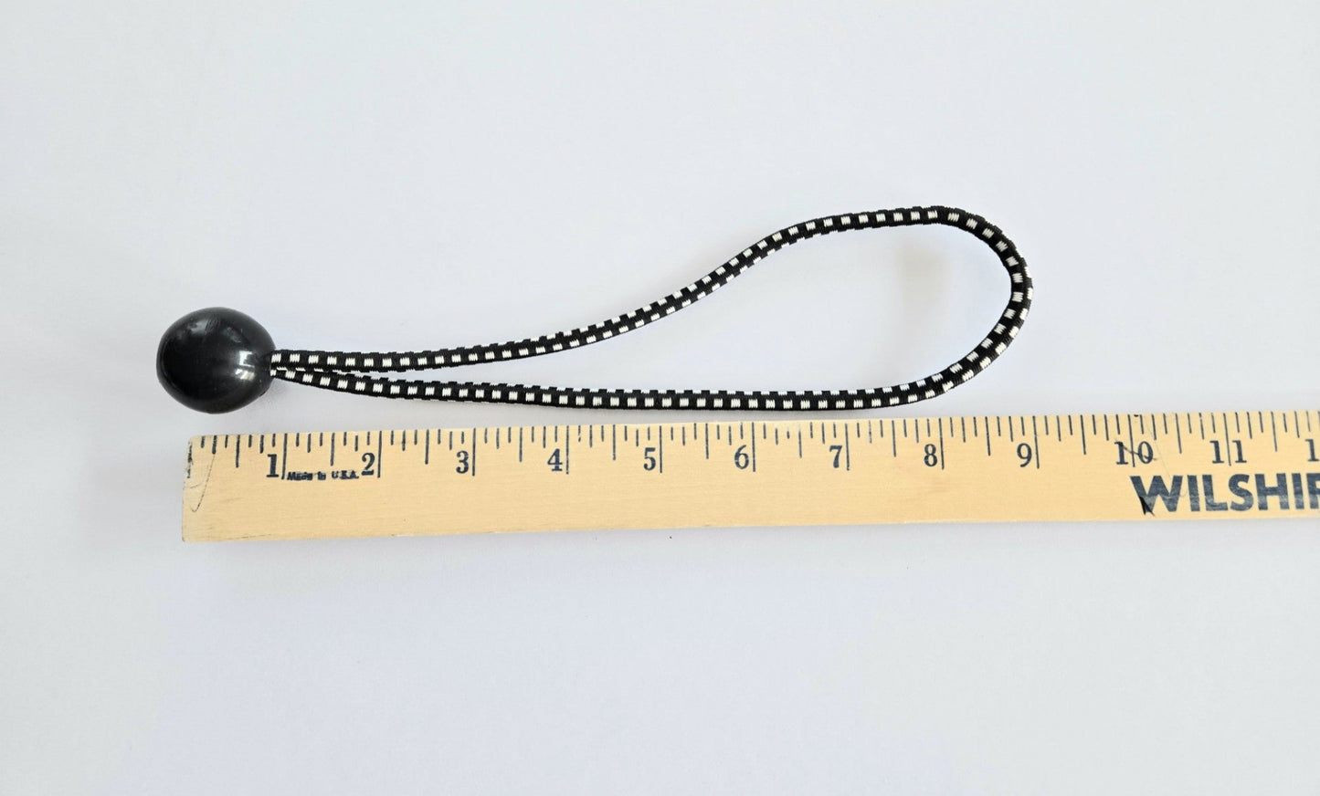 9 inch ball bungee measured against a wooden ruler.